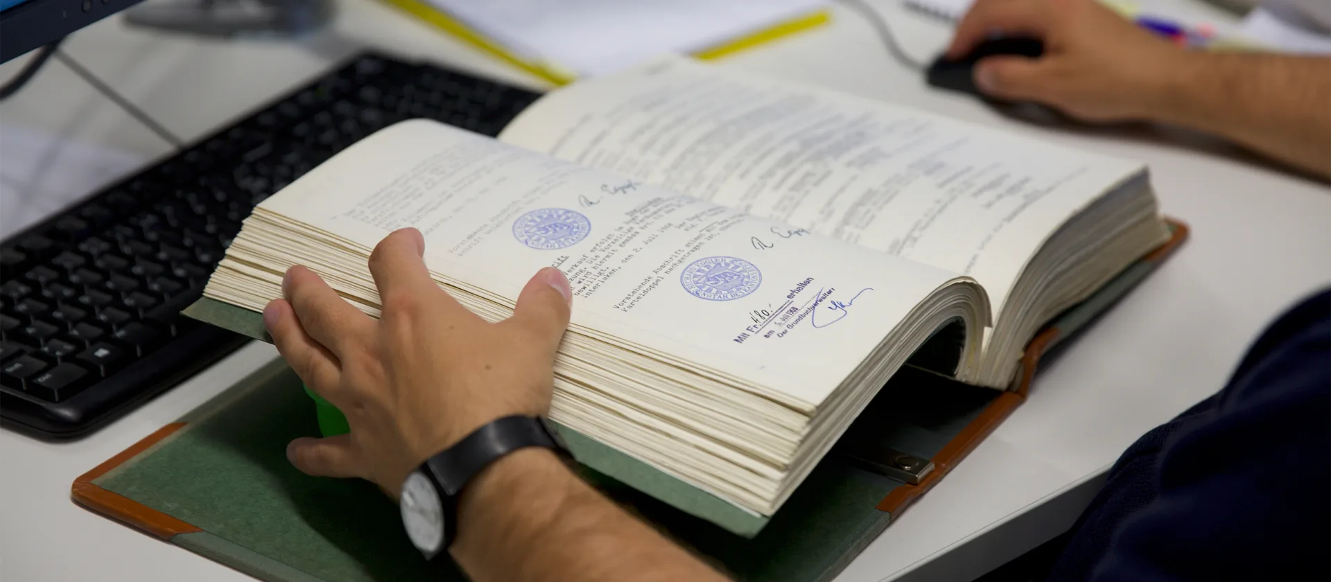 Eine Person hat ein altes offenes Buch vor sich